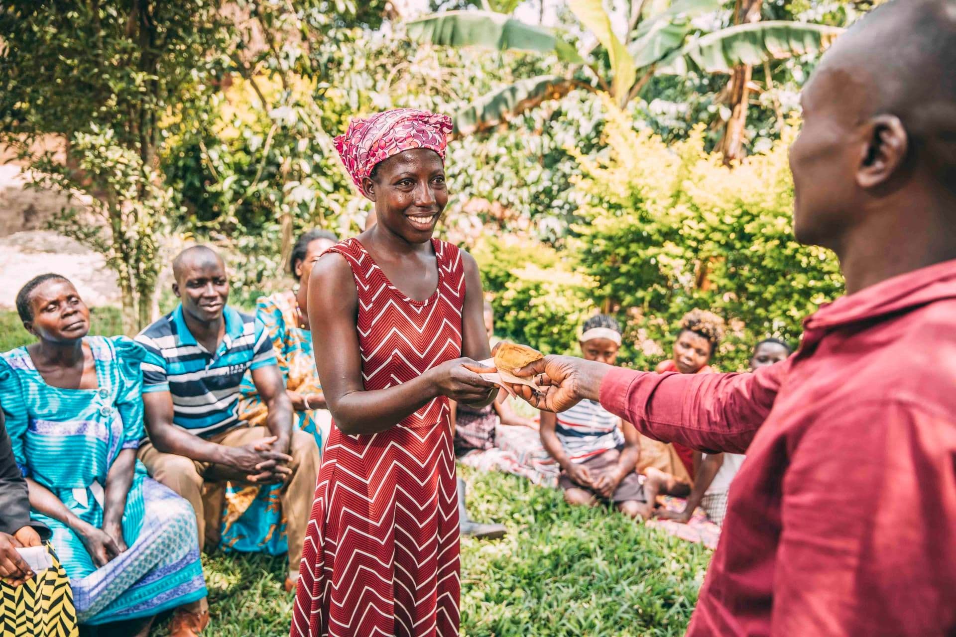 A female farmer receiving a loan from her cooperative during a VSLA session. A female farmer receiving a loan from her cooperative during a VSLA session.